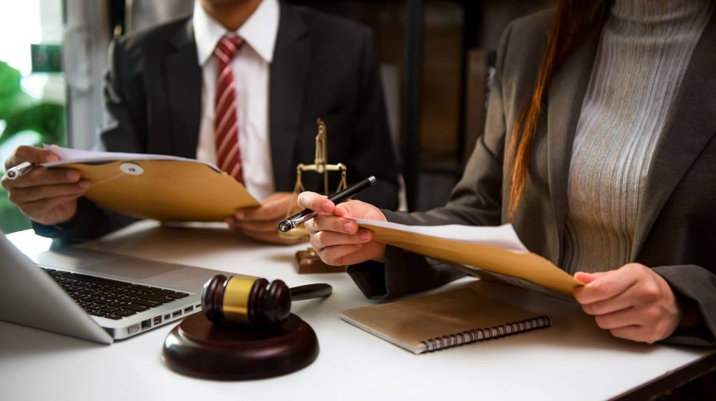 spouse signing documents for divorce with a lawyer